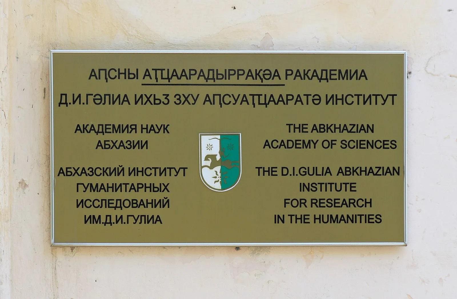 Табличка Абхазского института гуманитарных исследований имени Д. И. Гулиа в Сухуме: верхние строки на абхазском, с буквами ԥ, ҵ и ә (фото: Hons084, Wikimedia Commons, CC BY-SA 4.0)