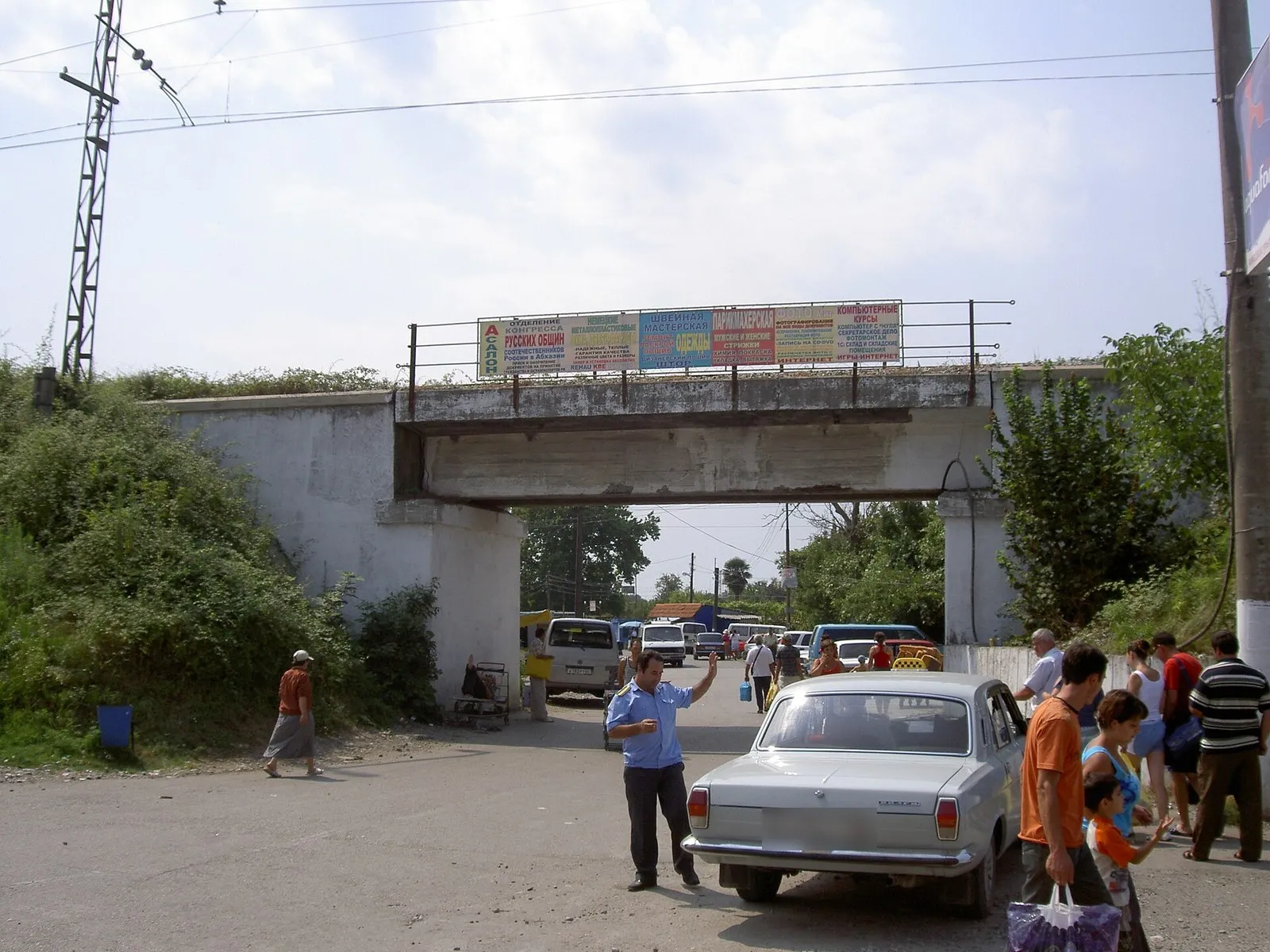 Такси и приезжие под железнодорожным мостом у станции Псоу на абхазской стороне, август 2008 года (фото: Dinamik, Wikimedia Commons, Public domain)