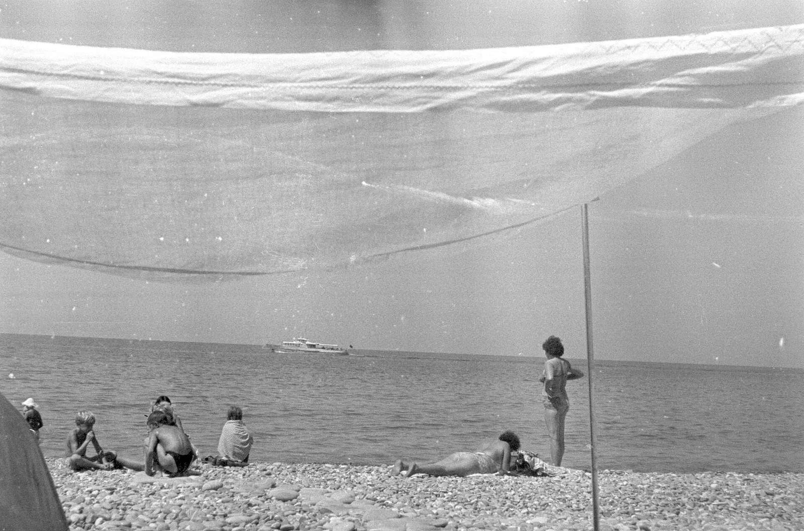 Лоо, июль 1968 года: отдыхающие на крупной гальке у самой воды, над ними натянут тент. В эти годы пляжи от Туапсе до Мзымты были самыми узкими за век (фото: Vyacheslav Argenberg / Transfer from A. S., Wikimedia Commons, CC BY 4.0)