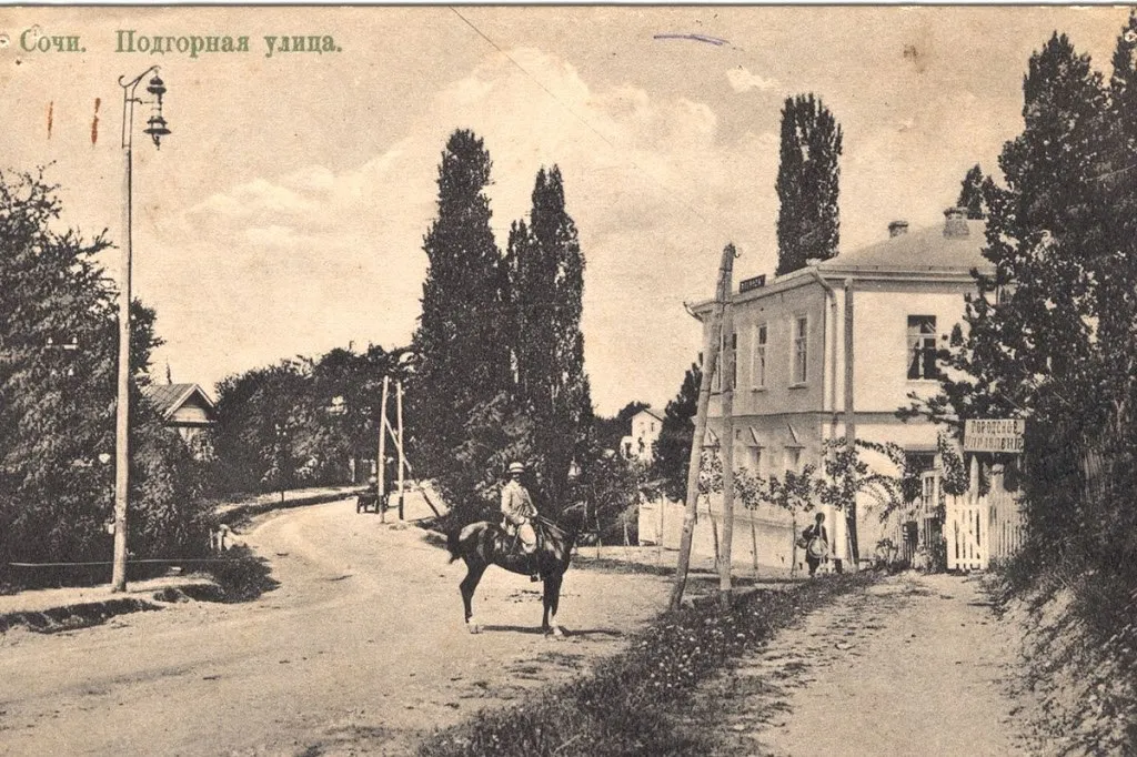Подгорная улица на открытке 1910 года: грунтовая дорога, тополя и всадник