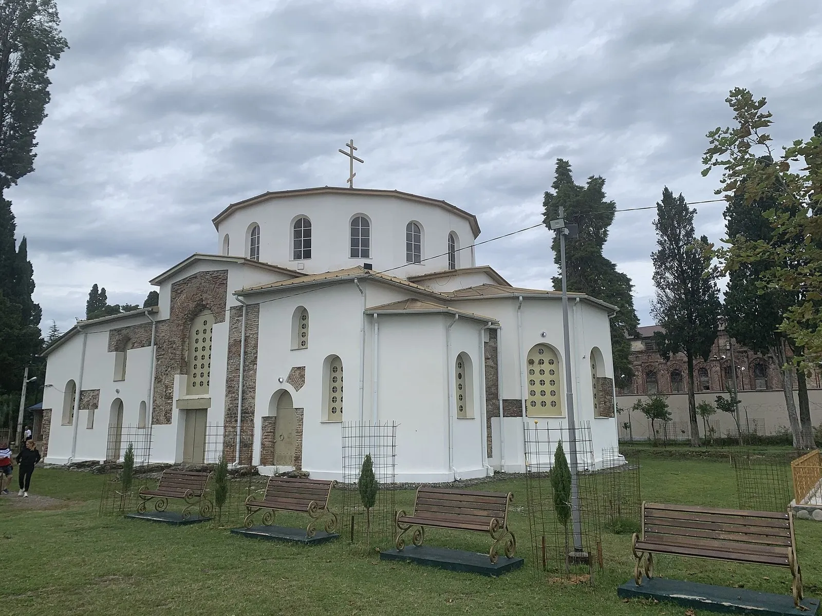 Драндский собор с востока: апсиды, барабан купола, белёные стены и сквер вокруг