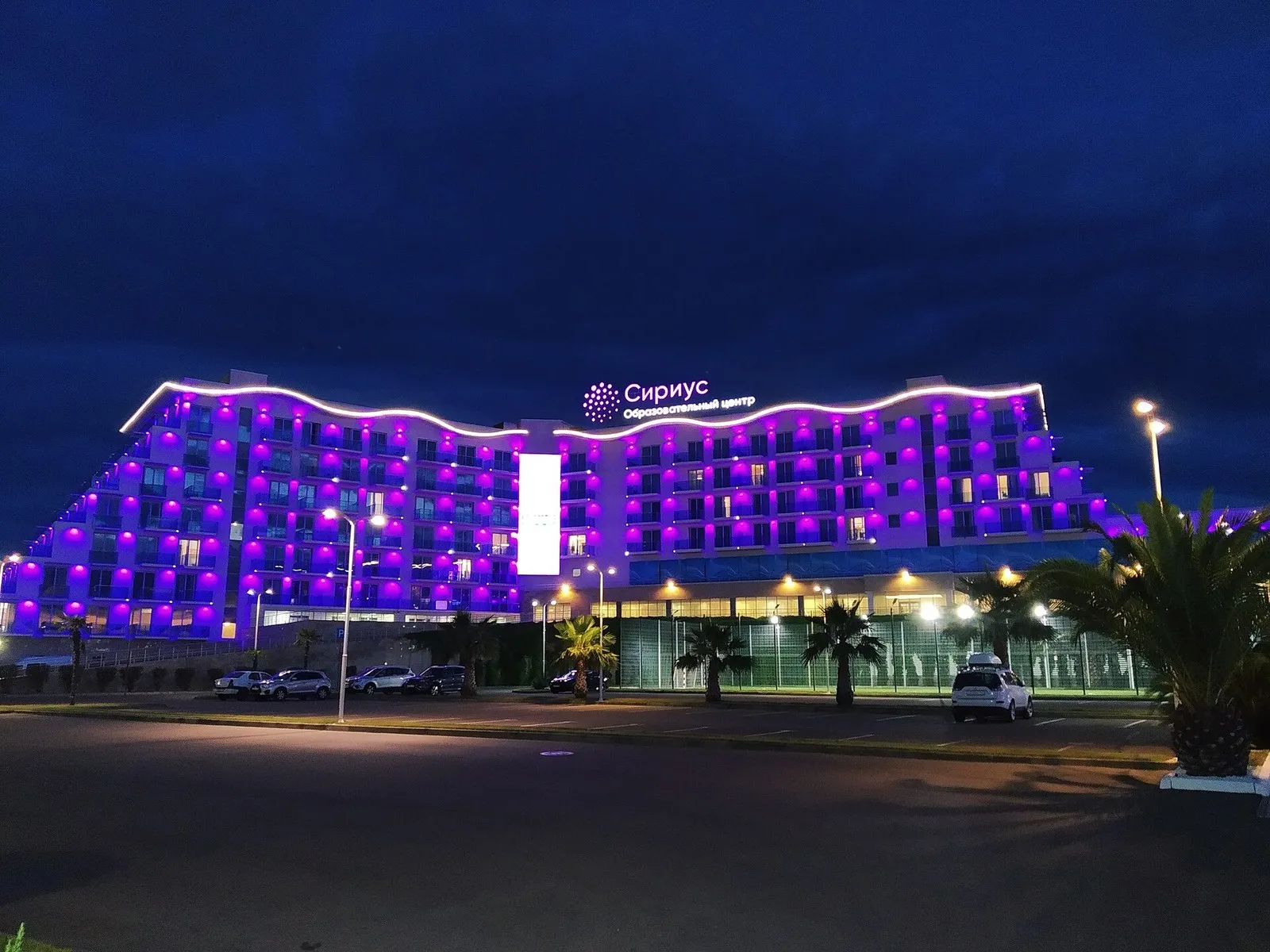 Корпус центра «Сириус» вечером: подсветка фасада и вывеска над входом