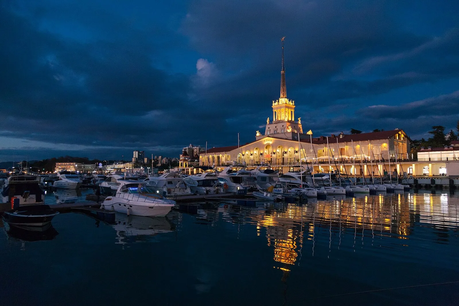 Морской вокзал и гавань Сочи в сумерках 23 ноября 2018 года: огни на шпиле, яхты у причалов