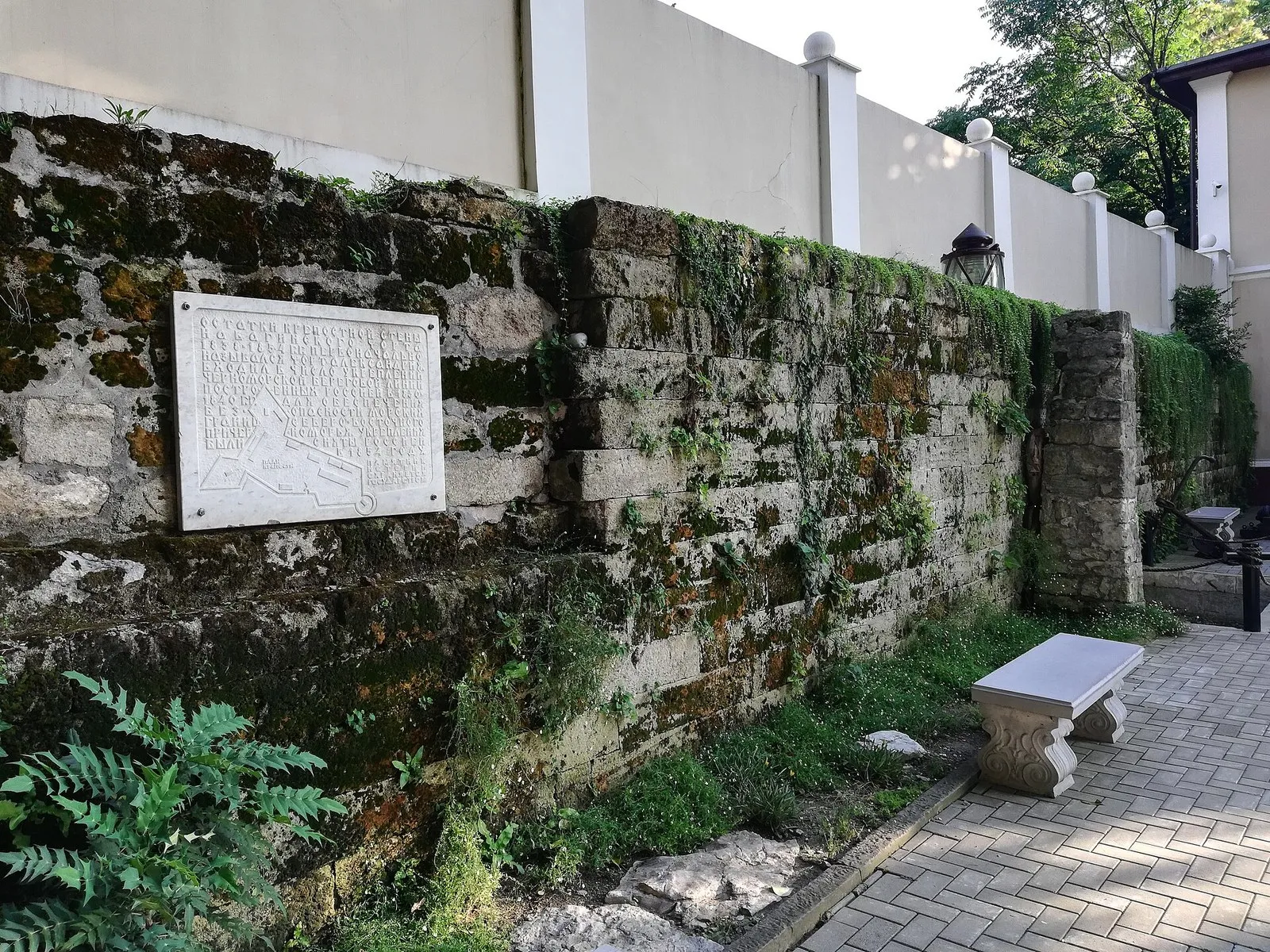 Уцелевший фрагмент северной стены форта с мемориальной доской, двор на улице Москвина, 7