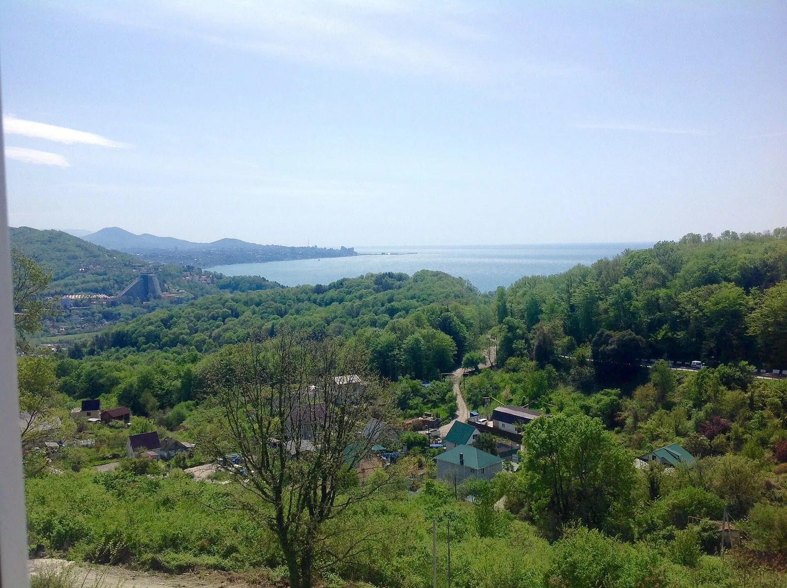 Вид на море и склон над Культурным Уч-Дере: зелёные холмы, крыши среди деревьев