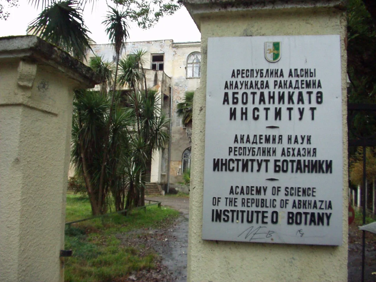 Табличка Института ботаники Академии наук Абхазии в Сухуме: название на абхазском, русском и английском