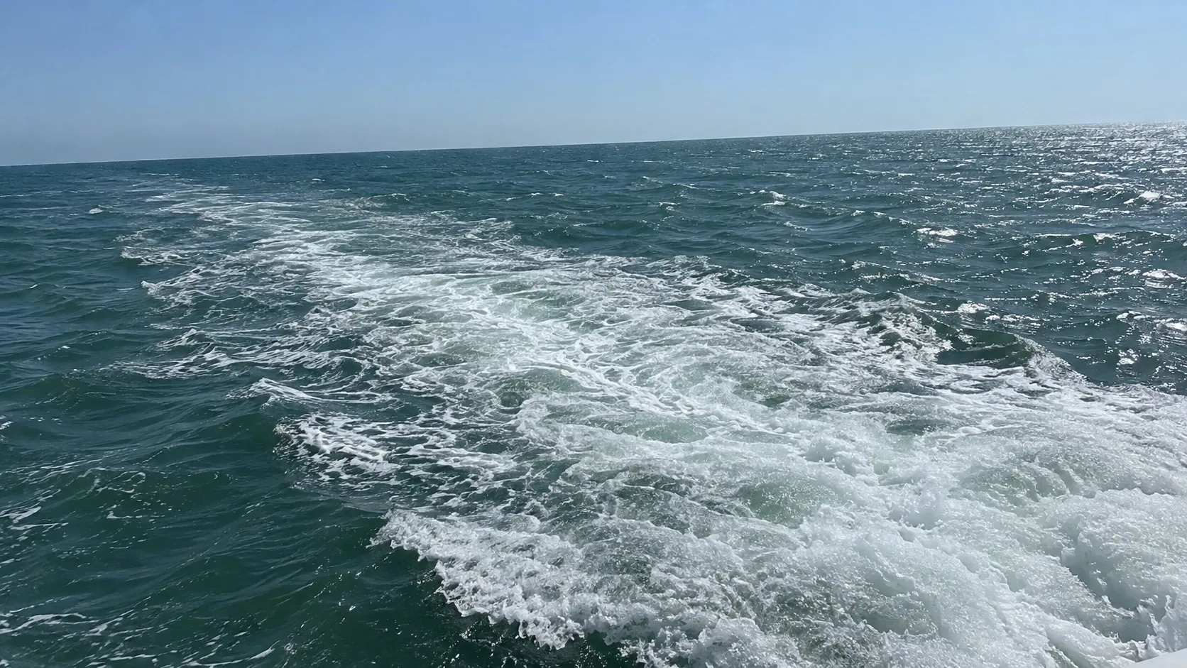 Белая пена за кормой на серо-зелёной морской воде (сгенерированная иллюстрация)