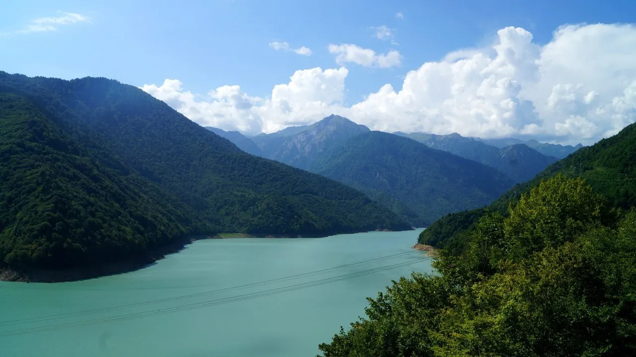 Водохранилище Ингурской ГЭС в августе 2015 года: вода бирюзовая, склоны покрыты лесом