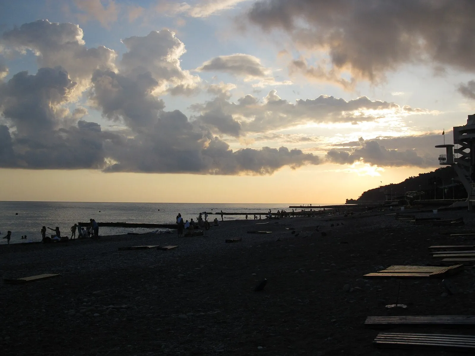 Облачная гряда над пляжем в Дагомысе на закате, у горизонта светлая полоса