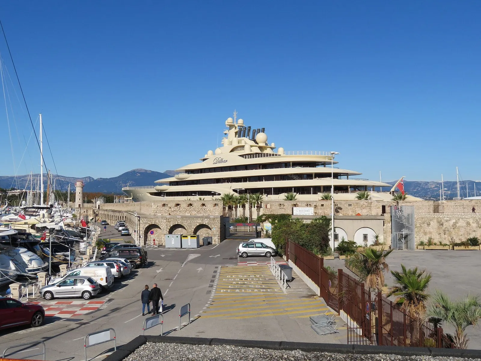 Надстройки Dilbar поднимаются над каменными постройками старого порта в Антибе, ноябрь 2019 года