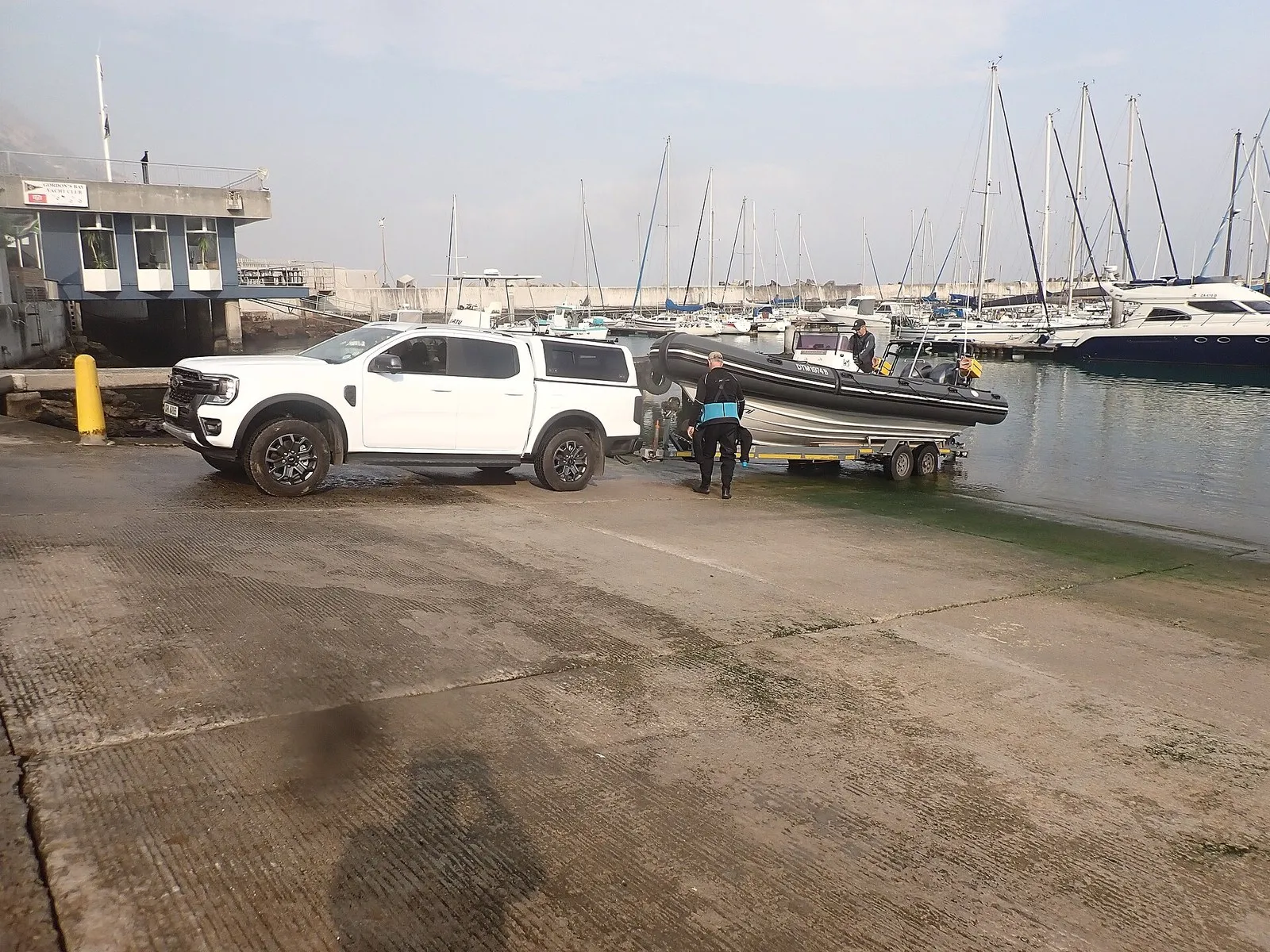 Надувная лодка с жёстким днищем на трейлере у спуска в воду