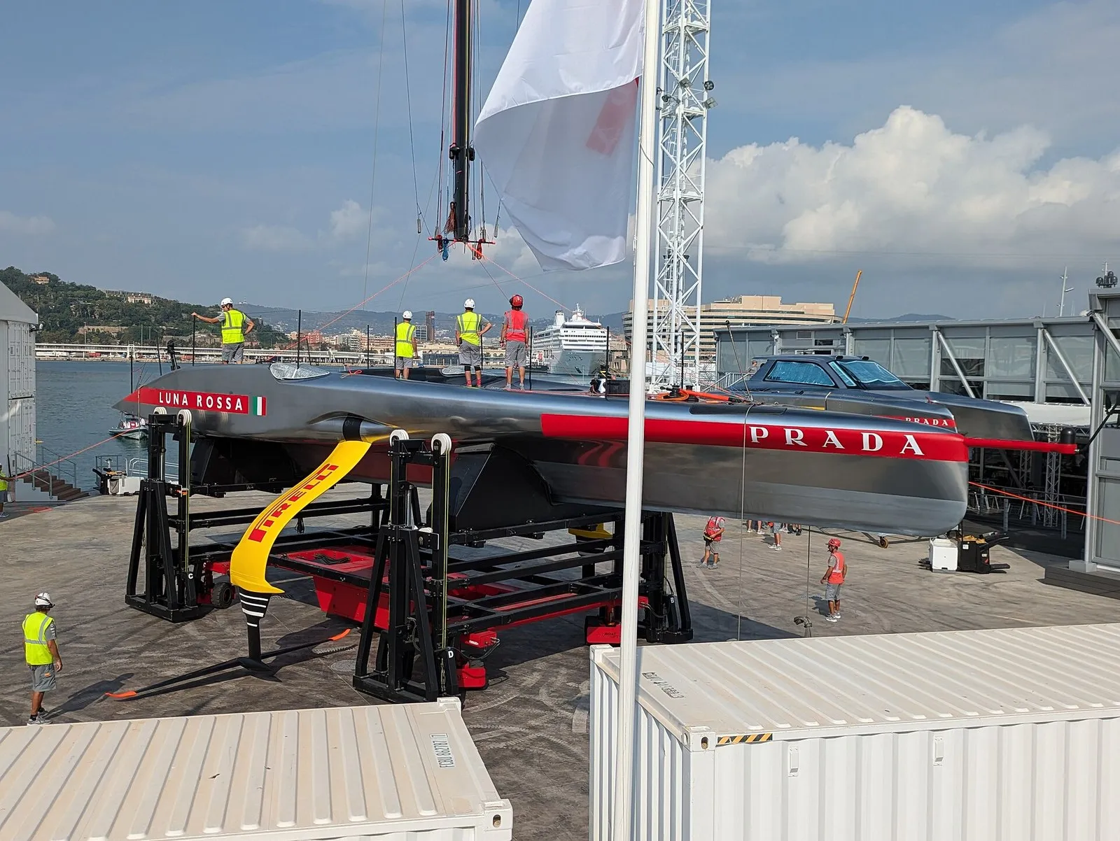 Яхта Luna Rossa на стапеле в Барселоне: под днищем нет киля, сбоку опущено крыло на рычаге
