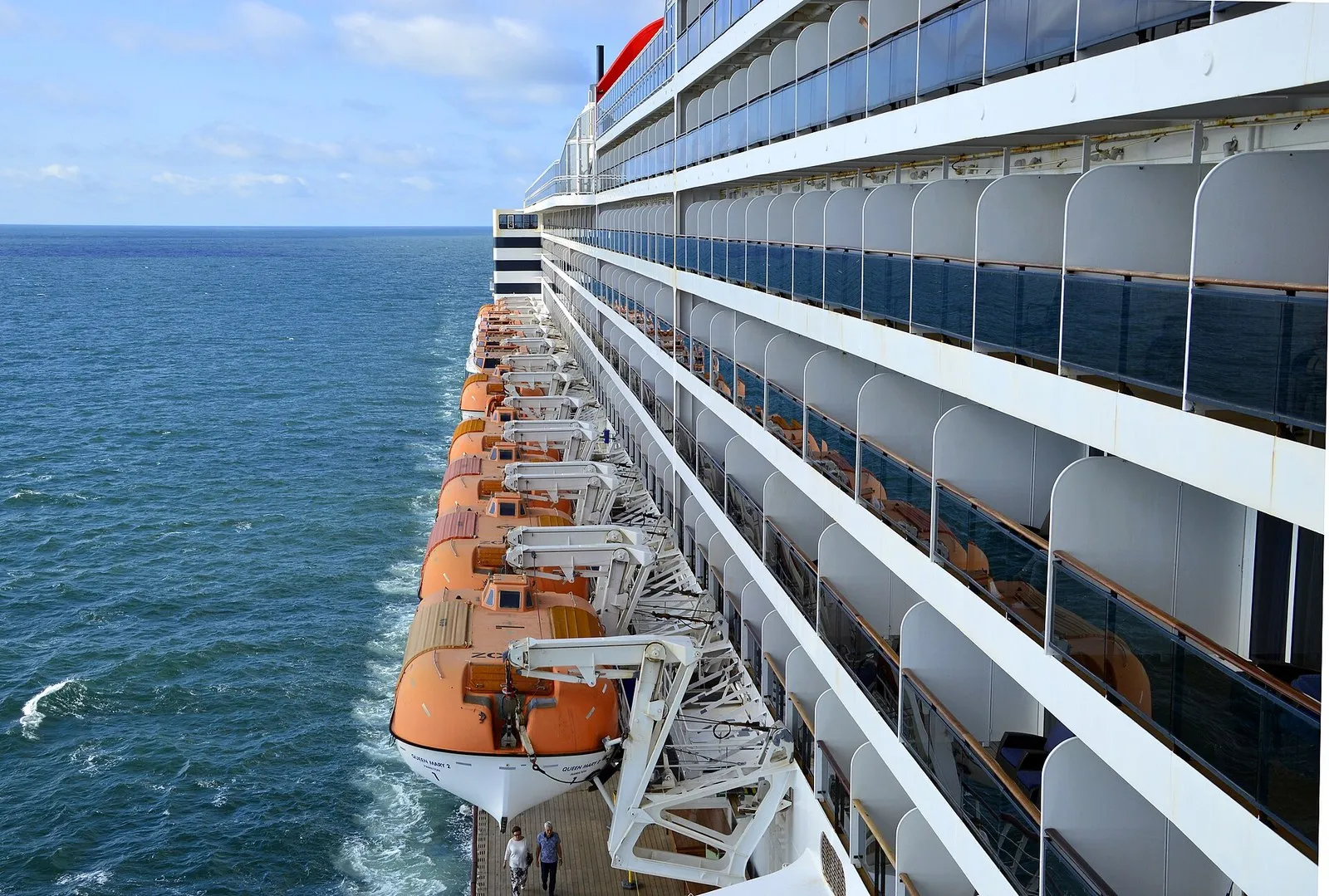 Queen Mary 2 в Северном море: вдоль борта подвешены оранжевые шлюпки, выше идут ряды кают с балконами