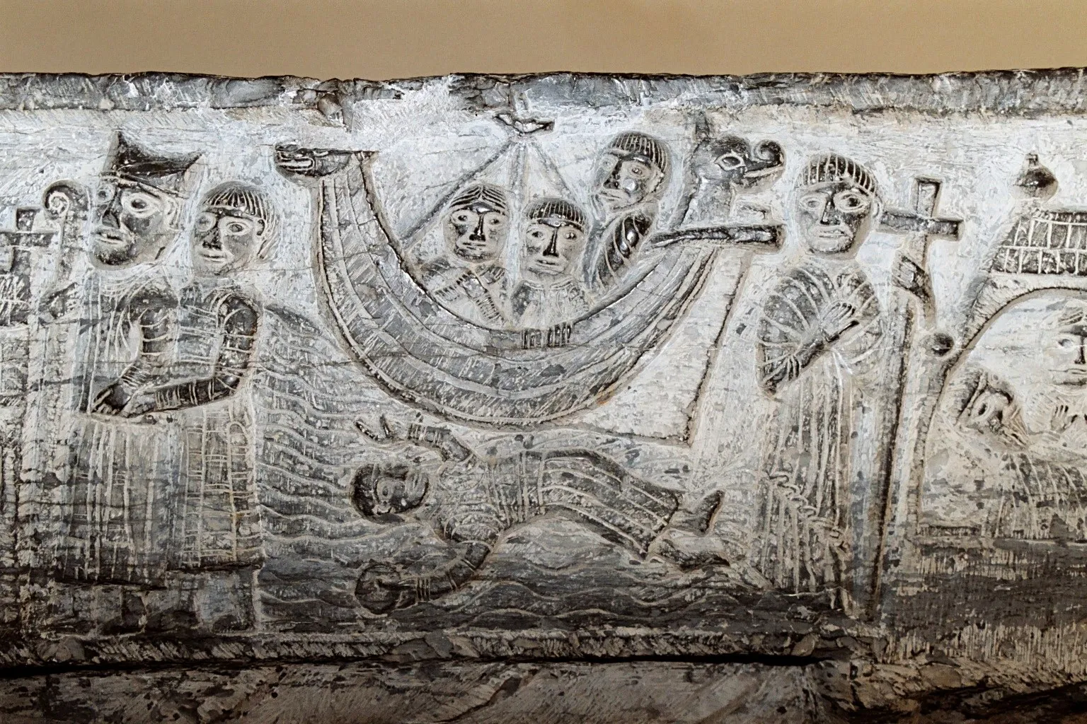 Резьба романской купели в Зеделгеме (Бельгия), XII век: корабль с людьми, ниже волны и человек в воде. Эту купель и винчестерскую называют древнейшими изображениями навесного руля в Европе (фото: EmDee, Wikimedia Commons, CC BY-SA 3.0)