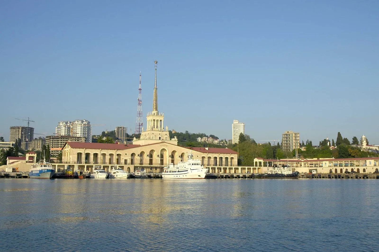 Морской вокзал Сочи со стороны гавани: шпиль, арки, у причала катера, яхты и теплоход. Таким его видно в первые минуты выхода из Морского порта (фото: Ганощенко Роман (Ganoshenko Roman), Wikimedia Commons, CC BY-SA 3.0)