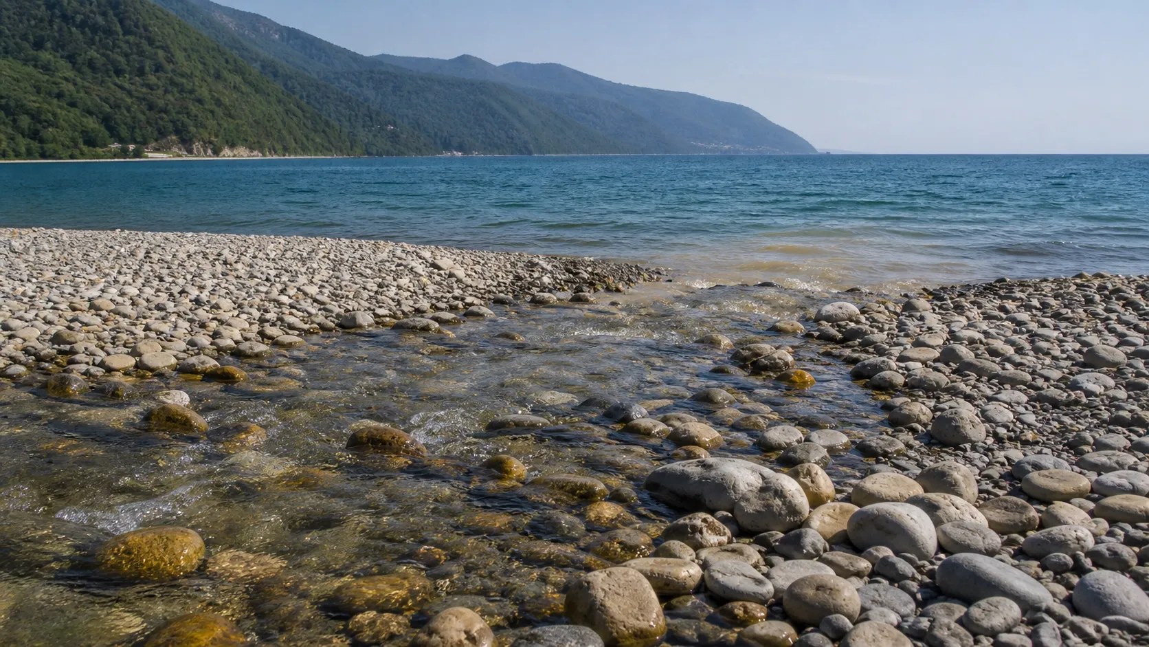 Горный ручей выходит на гальку и мутит воду у берега: именно из таких потоков и намывали золото