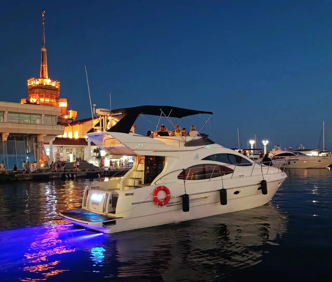 Ночь у Морского порта Сочи: подводная подсветка красит воду за кормой в фиолетовый. Свечение над морем в 1927-м объяснили прозаичнее — метан и гроза